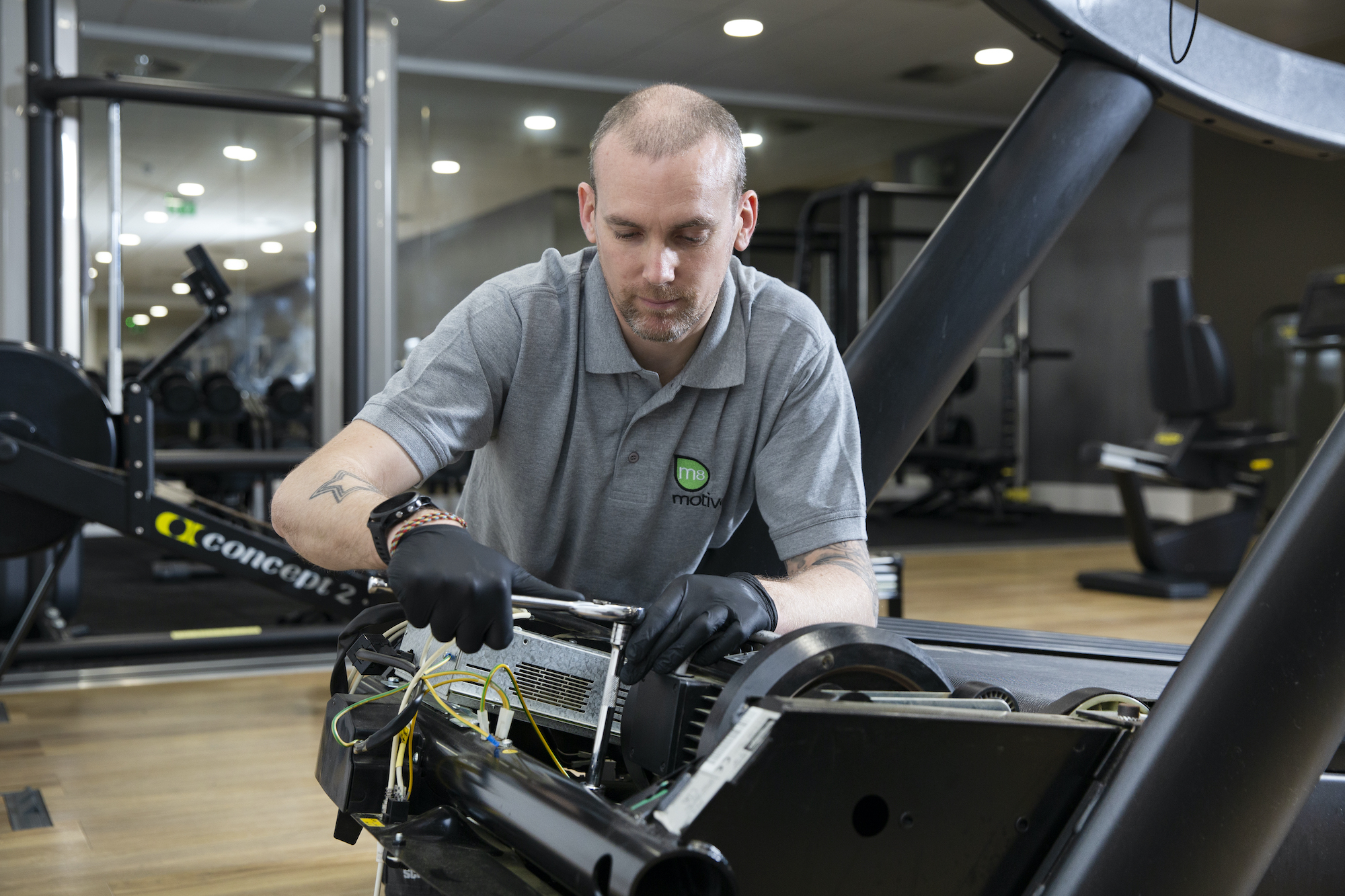Man repairing a treadmill